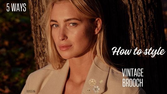 5 ways to style a vintage brooch. A model is wearing a camel color coat and gold vintage brooches with pearls. 