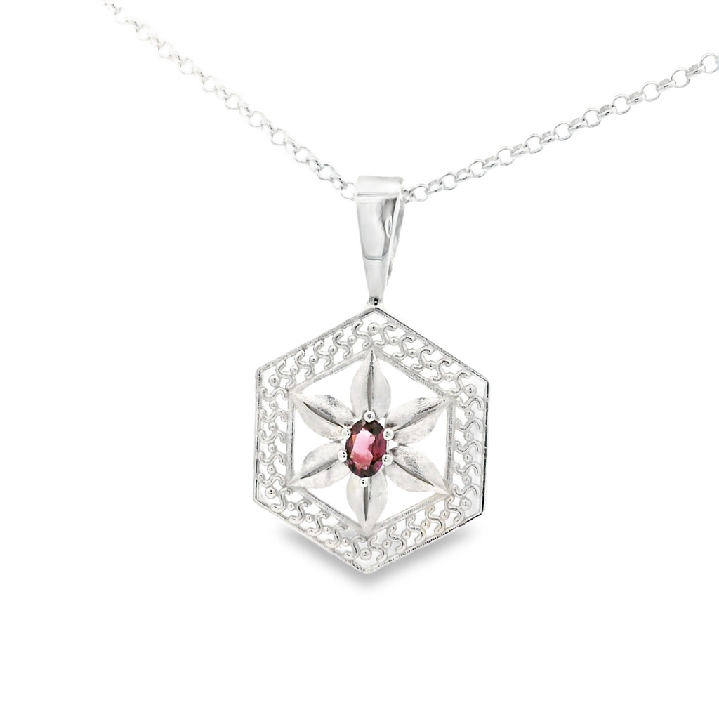 Silver hexagonal pendant with a spinel gemstone on a white background