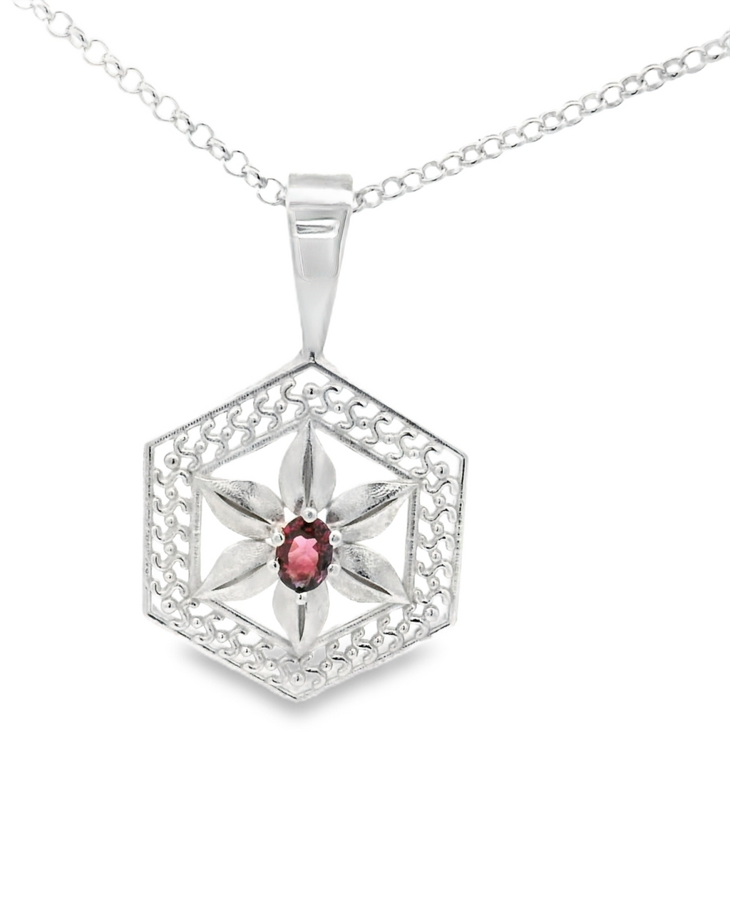 Silver hexagonal pendant with a spinel gemstone on a white background