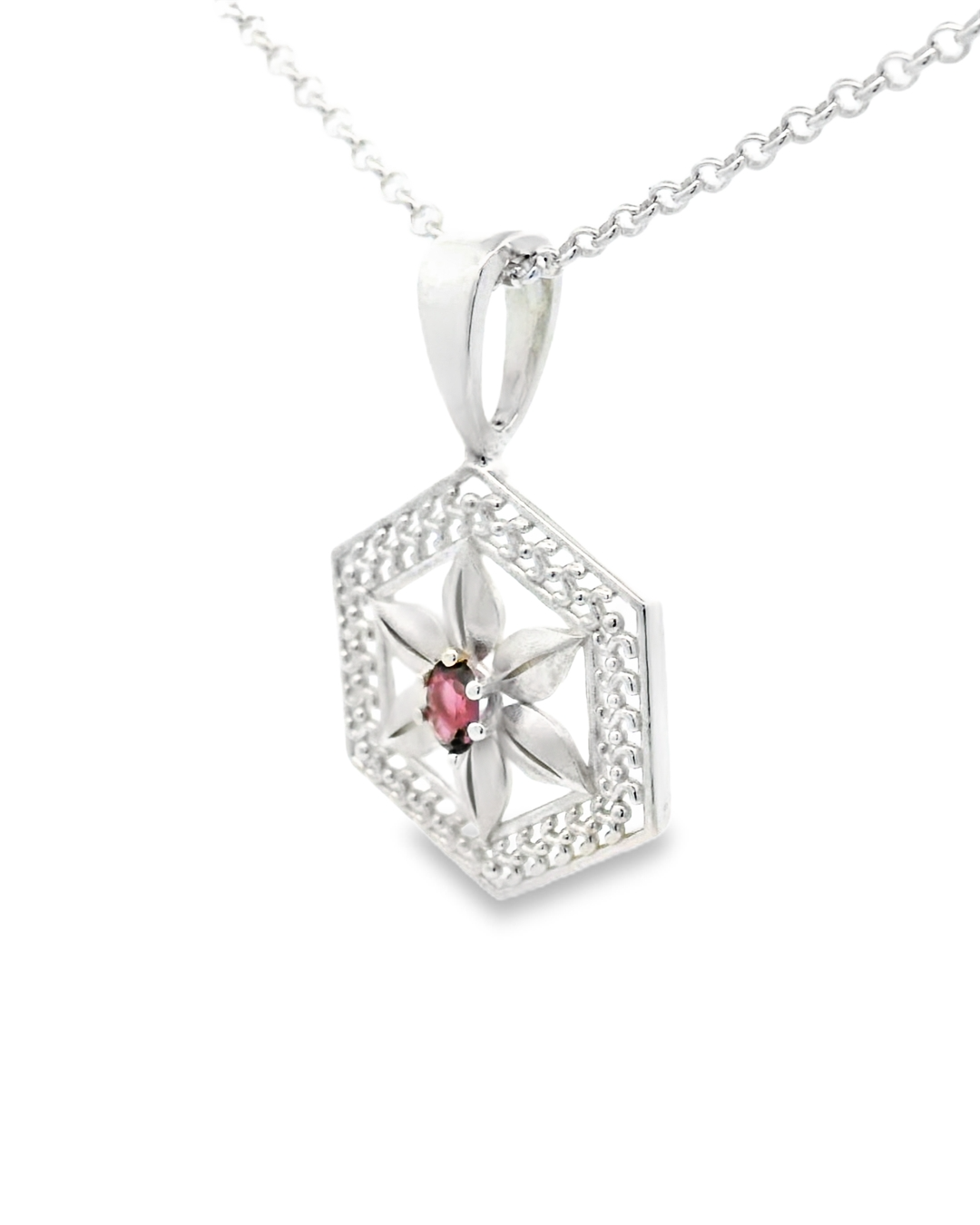 Silver hexagonal pendant with a spinel gemstone on a white background