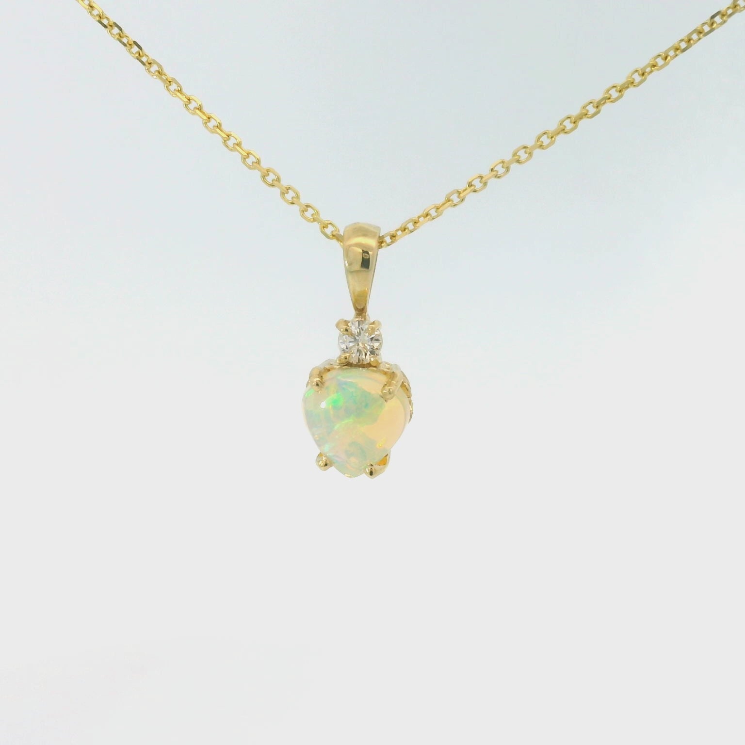 Gold necklace with a heart-shaped pendant on a white background